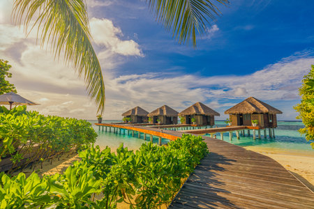 Amazing beach landscape. Beautiful Maldives sunset seascape. Horizon colorful sea sky clouds, over water villa pier pathway. Tranquil island lagoon, tourism travel backgroundの写真素材