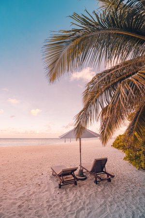 Romantic beach landscape. Couple chairs umbrella sunset sunrise colorful sky clouds. Dream beach honeymoon vacation. Best love destination travels. Amazing leisure relax wellbeingの写真素材