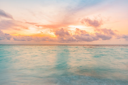 Inspire meditation. Cloudy sky, blue and pink glowing clouds, soft golden sunlight. Water surface texture. Picturesque dreamlike seascape, cloudscape, nature. Panoramic viewの写真素材