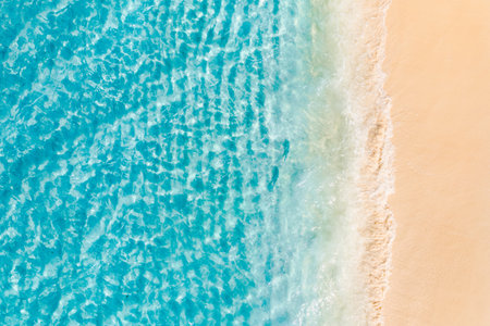Summer seascape beautiful waves, blue sea water sunny day. Top view from drone. Sea aerial amazing tropical nature background. Beautiful bright sea with waves splashing beach sandの写真素材