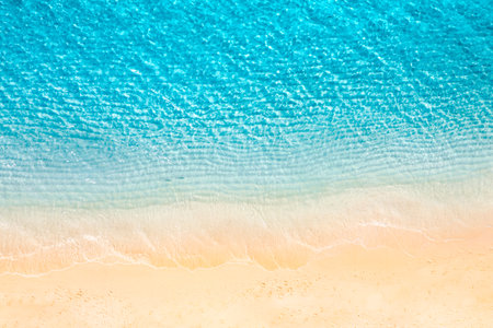 Summer seascape beautiful waves, blue sea water sunny day. Top view from drone. Sea aerial amazing tropical nature background. Beautiful bright sea with waves splashing beach sandの写真素材