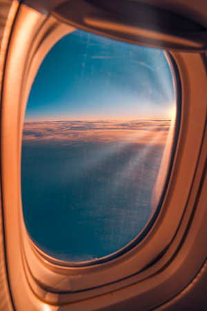 Beautiful sunset view from airplane window with glowing sky clouds and horizon perfect for travel...