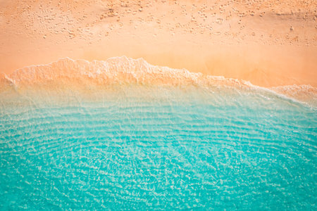Relaxing aerial top view of golden sand beach with calm waves and peaceful shore, tropical Mediterranean landscape with relaxing summer vacation travel vibesの写真素材