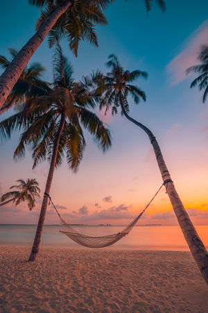 Majestic sunset beach scene featuring colorful sky palm trees hammock swing over sea view carefree atmosphere vibes. Freedom peaceful serene tranquil tropical vacation backgroundの写真素材