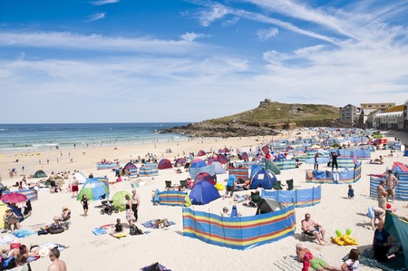 SAINT IVES, CORNWALL - AUGUST 8: Tourists and locals enjoy the beach in St. Ives, in Cornwall,...