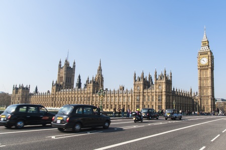 LONDON, UK - APRIL 02: Famous black cab driving by Houses of Parliament, with Big Ben prominent in the picture. April 02, 2012 in London.のeditorial素材