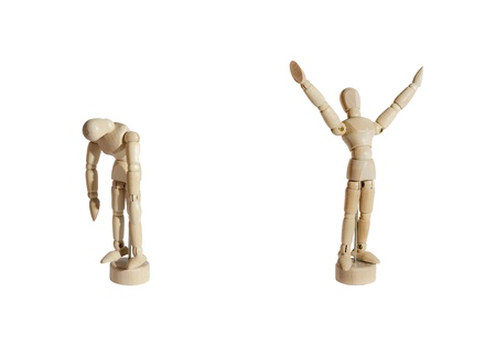 Two wooden mannequins, one celebrating and the other sad, against white background.の写真素材