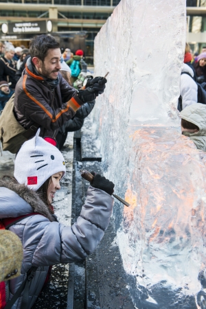 LONDON, UK - JANUARY 13: Public activity at the London Ice Sculpture Festival, in Canary Wharf. Visitors were invited to carve this block of ice. January 13, 2013 in London.のeditorial素材