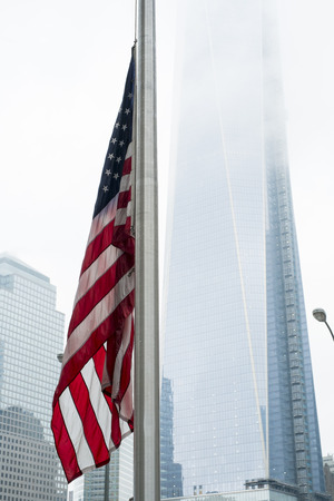 NEW YORK, US - NOVEMBER 22: American flag with new World Trade Centre building engulfed by low hanging clouds. November 22, 2013 in New York.のeditorial素材