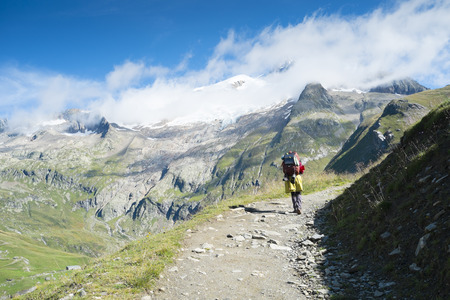 VILLE DES GLACIERS, FRANCE - AUGUST 27: Hiker walking towards Glacier Needles. The region is a stage at the Mont Blanc tour, which crosses three countries. August 27, 2014 in Ville des Glaciers.のeditorial素材