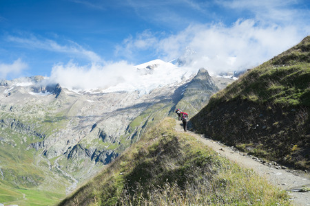 VILLE DES GLACIERS, FRANCE - AUGUST 27: Hiker walking towards Glacier Needles. The region is a stage at the Mont Blanc tour, which crosses three countries. August 27, 2014 in Ville des Glaciers.のeditorial素材