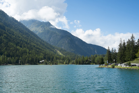 CHAMPEX, SWITZERLAND - AUGUST 30: Placid lake with tree covered mountains in the background. The village is one of the Mont Blanc tour stages. August 30, 2014 in Champex.のeditorial素材