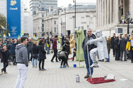 LONDON, UK - OCTOBER 26: Street artists levitating in busy Trafalgar Square. In central London, street artists must obtain a permit in order to perform in public spaces. October 26, 2014 in London.のeditorial素材