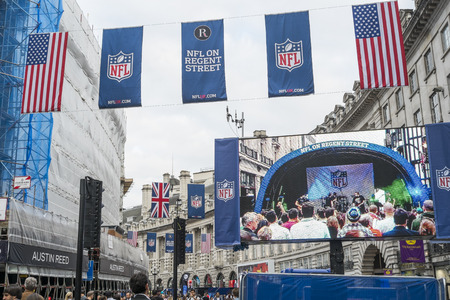 LONDON, UK - SEPTEMBER 27: American flag and NFL banners hanging above screen on Regent street. September 27, 2014 in London. Regent street was closed to traffic to host NFL related games and events.のeditorial素材