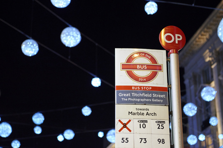 LONDON, UK - DECEMBER 20: Nighttime shot of London bus stop with Christmas lights in the background. December 20, 2014 in London.のeditorial素材