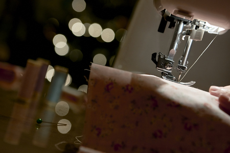 Low key detail of automatic sewing machine needle shot from the sideの写真素材