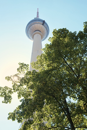 BERLIN, GERMANY - JULY 07: Low angle shot of TV tower in Alexanderplatz, with tree branches in the foreground. July 07, 2015 in Berlin.のeditorial素材