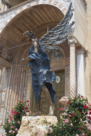VERONA, ITALY - JULY 13: Bronze statue The Blue Angel of Acceptance, or Hospitality, by Albano Poli, in front of Duomo di Verona Cathedral. July 13, 2015 in Verona.のeditorial素材