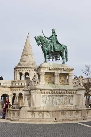 BUDAPEST, HUNGARY - FEBRUARY 02: Bronze statue of Saint Stephen, in the Old Town district, with Fisherman's Bastion spire in the background. February 02, 2016 in Budapest.のeditorial素材