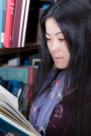 A young female student reading in the library.の写真素材