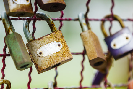Close-up shot of old vintage rusty key locks on an old metal fence with blur background.の写真素材