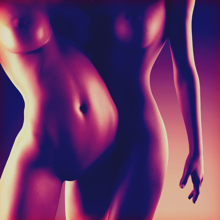 Two beautiful nude sexy lesbian women in erotic foreplay game in dark studioの写真素材