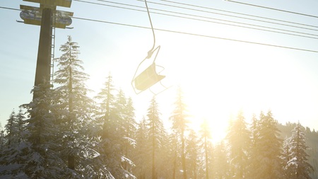 empty ski lift. chairlift silhouette on high mountain over the forest at sunsetの写真素材
