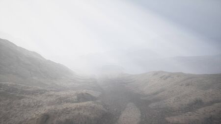 the sun's rays against the backdrop of the mountains and the lava-rocky wet shore in the foregroundの写真素材