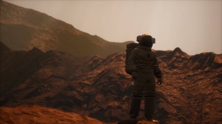 Spaceman walks on the red planet Mars. Space Mission. Astronaut travel in spaceの写真素材