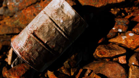 rusty destroyed metal barrel on beach rocks