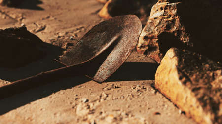 old rusty shovel on wet sand at the beachの写真素材
