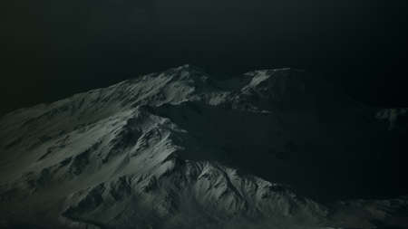 Dramatic dark rocky mountain with patches of snow in stormの写真素材