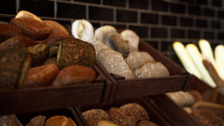 A variety of different types of doughnuts are beautifully presented and arranged for customers to...