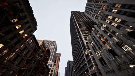 In a vibrant urban setting, towering skyscrapers loom overhead as the sun sets, casting a dramatic...