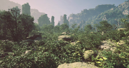 This vibrant landscape showcases dense foliage and towering rock formations under a bright sky, creating a serene and untouched natural environment.の写真素材