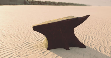 A solitary black anvil sits atop sun kissed sand, the waves gently lapping in the distance. The fantastic contrast of the dark metal against the light sandy texture creates a striking visual.の写真素材