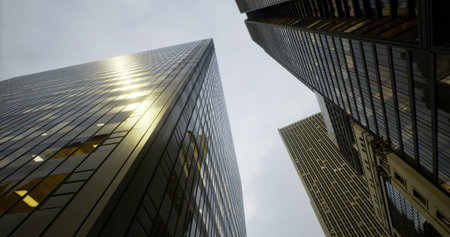 Looking up at towering skyscrapers gleaming under a dull sky, glass reflects faint light as urban energy pulses below in a vibrant city filled with life and activity.の写真素材