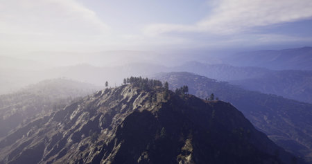 Breathtaking mountain peak rises above the valley, enveloped in gentle mist at dusk. Soft hues illuminate the terrain, revealing lush green trees and distant hills, capturing natures serene beauty.の写真素材