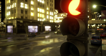 Bright red traffic light illuminates the street in a bustling city. Surrounding buildings reflect...