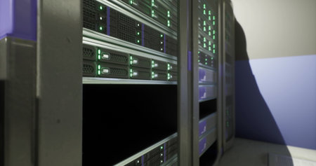 Rows of servers are illuminated with green lights in a data center. This high tech facility is...