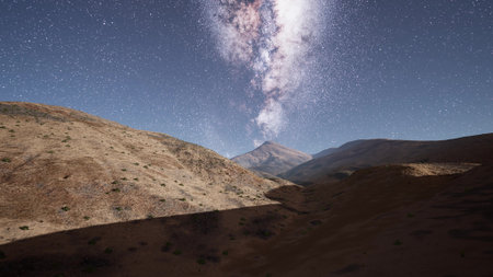 A stunning landscape showcases a rugged mountainside illuminated by the vast expanse of starry night...