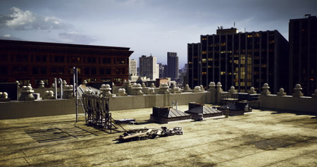 Rooftop space features scattered construction materials against a backdrop of urban skyline. City...