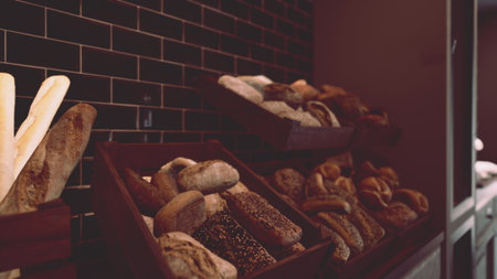 Various types of breads and pastries are neatly arranged in baskets on a countertop in a store.