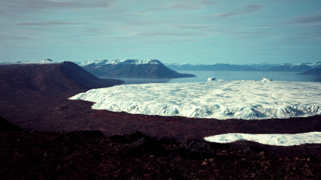 In a stunning scene, vast glaciers rest on rugged terrain, with icy formations glistening under soft...