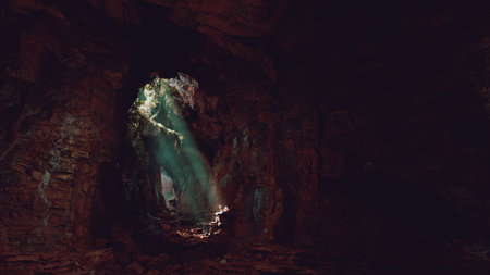 Sunlight filters into a dark cave, casting ethereal beams on weathered stone. Shadows dance on the walls, revealing natures artistry in this hidden underground realm.の写真素材