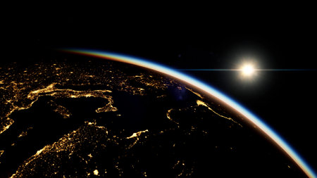A breathtaking view of Earth illuminated by city lights under a dark sky. The sun rises above the horizon, casting a golden glow over the planet, showcasing its beauty and majesty.の写真素材