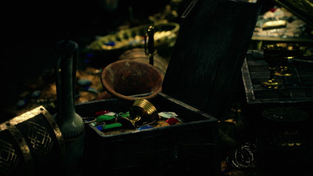 A collection of ornate artifacts shines softly in a dark cavern, revealing a treasure trove of...