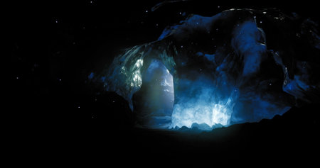 A stunning cave in complete darkness features brilliant blue lighting that highlights its contours....