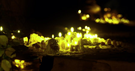 Small flickering candles rest among shimmering crystals, casting warm light in a dim environment. The peaceful atmosphere invites reflection and serenity.の写真素材