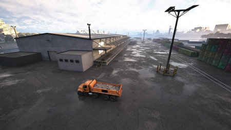A truck is captured in motion as it drives on a street adjacent to a building.